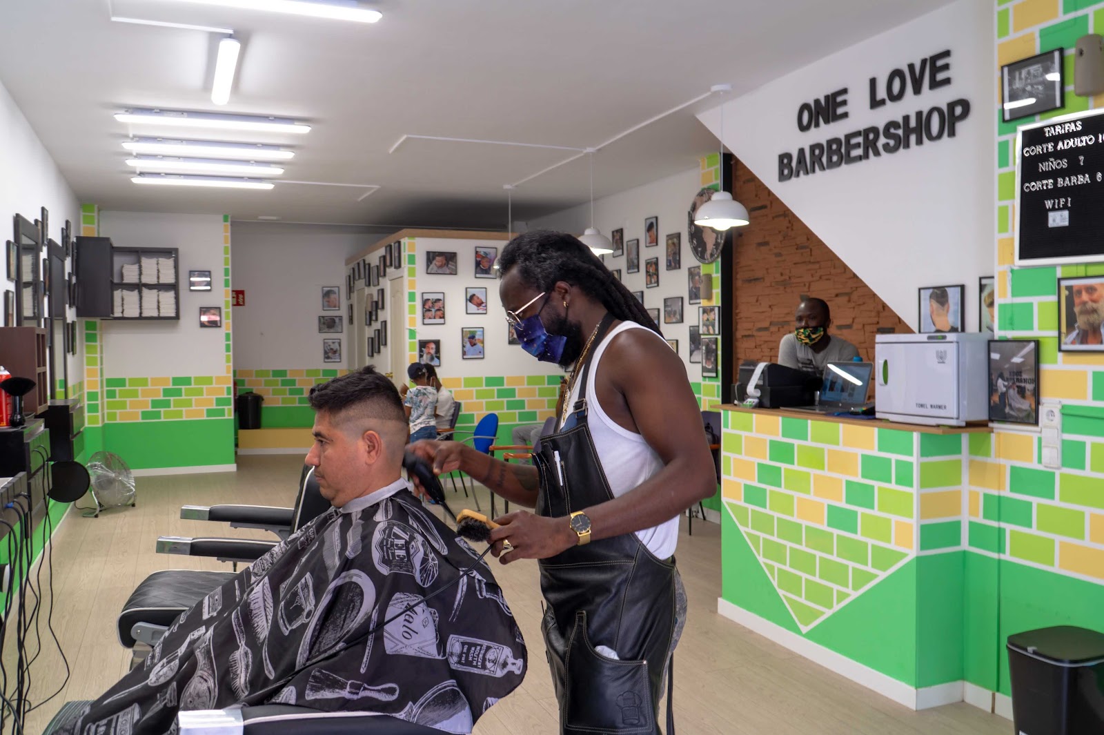 Inside One Love Barbershop, with the shop's sign on the wall