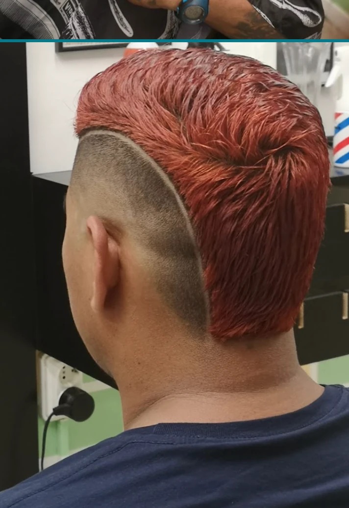A red-dyed haircut with a sharp fade, done at One Love Barbershop