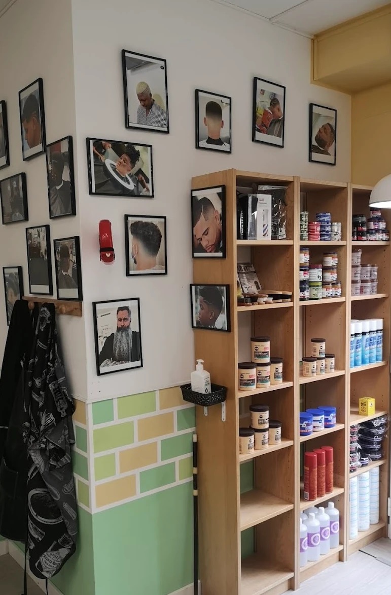 Wall of client photos and grooming products at One Love Barbershop